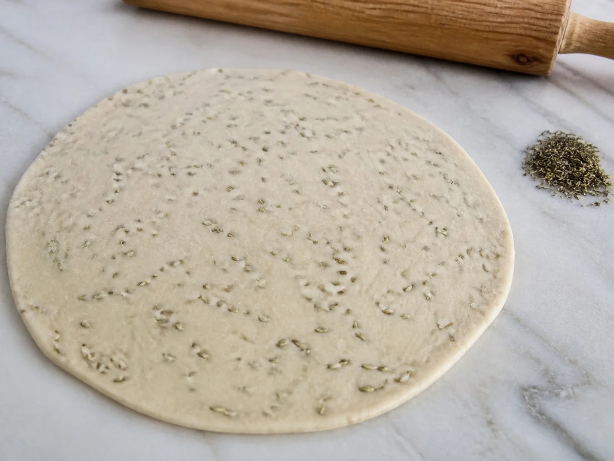 Lightly crushed fennel seed pieces embedded in flatbread dough with thyme separate - carom seed substitutes | KnowTheSpices