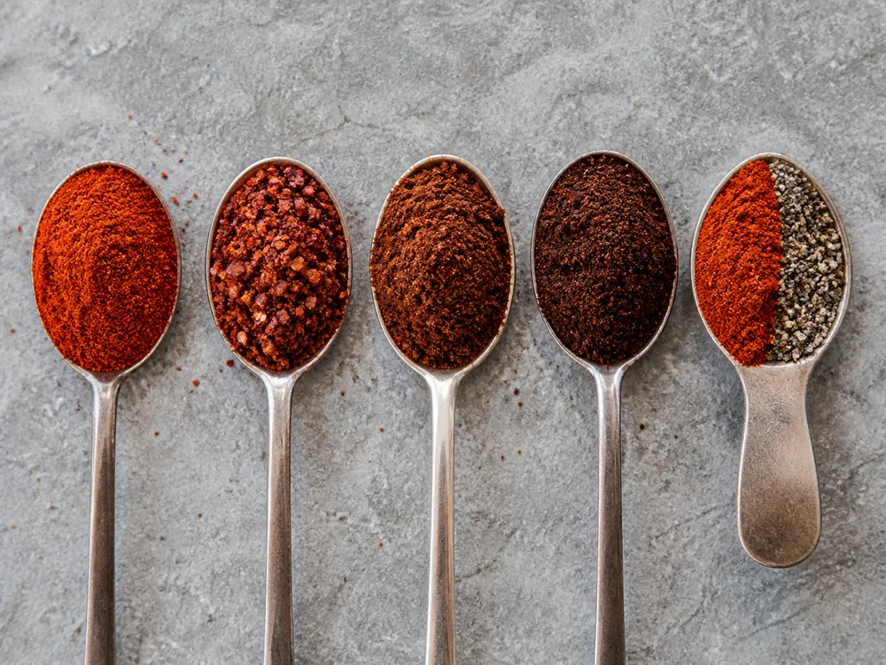 Hot paprika, Aleppo pepper, chipotle, ancho, and smoked paprika with black pepper in measured portions - cayenne pepper substitutes | KnowTheSpices