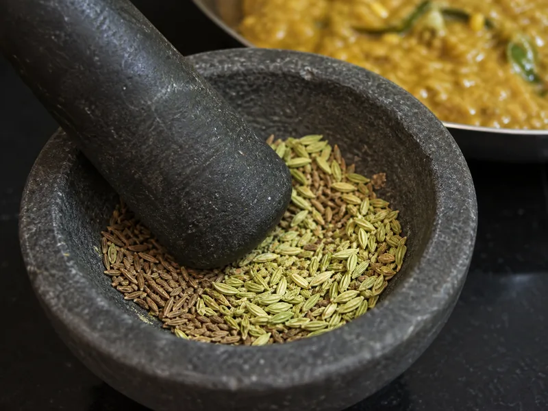 Brown cumin seeds and pale green fennel seeds partly crushed together - coriander-seed-substitutes | KnowTheSpices