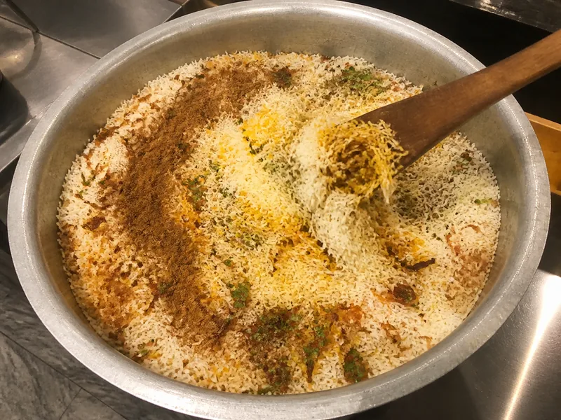 Garam masala sprinkled over biryani rice before one gentle fold - coriander-seed-substitutes | KnowTheSpices