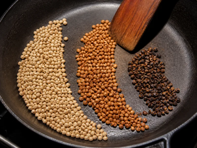 Raw, fragrant, and over-dark substitute seeds separated in a skillet - coriander seed substitutes | KnowTheSpices