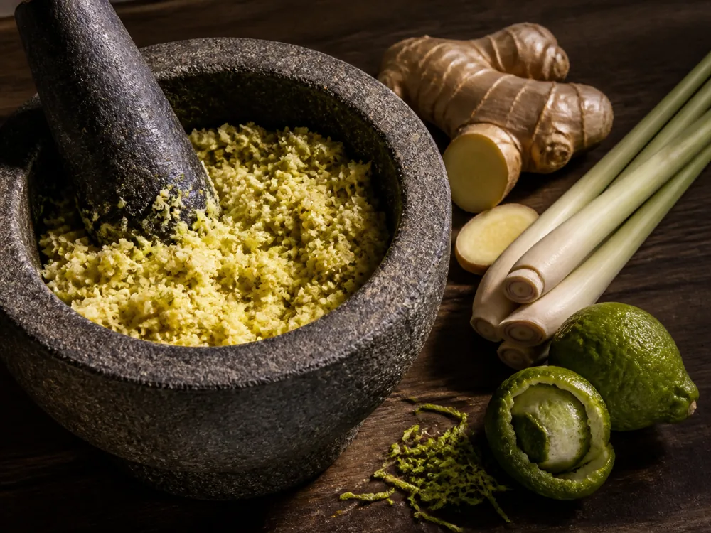 Young ginger and tender lemongrass being pounded into a smooth curry paste - galangal substitute for curry paste | KnowTheSpices