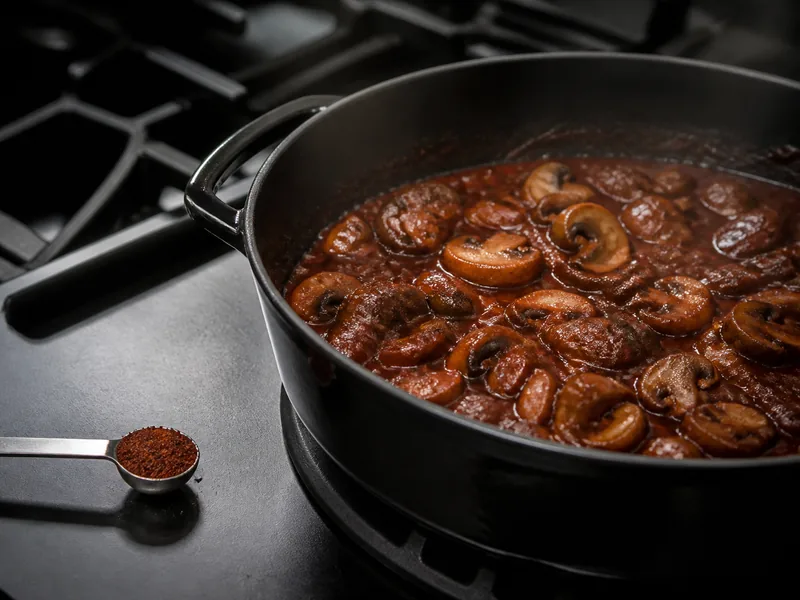 A small chipotle powder measure beside a dark mushroom braise - gochugaru substitutes | KnowTheSpices