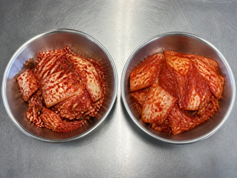 Flecked and smooth red chile pastes coating equal napa cabbage portions - gochugaru substitutes | KnowTheSpices