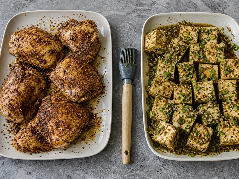 Dry-rubbed chicken beside tofu coated in a scallion and lime marinade - jerk seasoning substitutes | KnowTheSpices