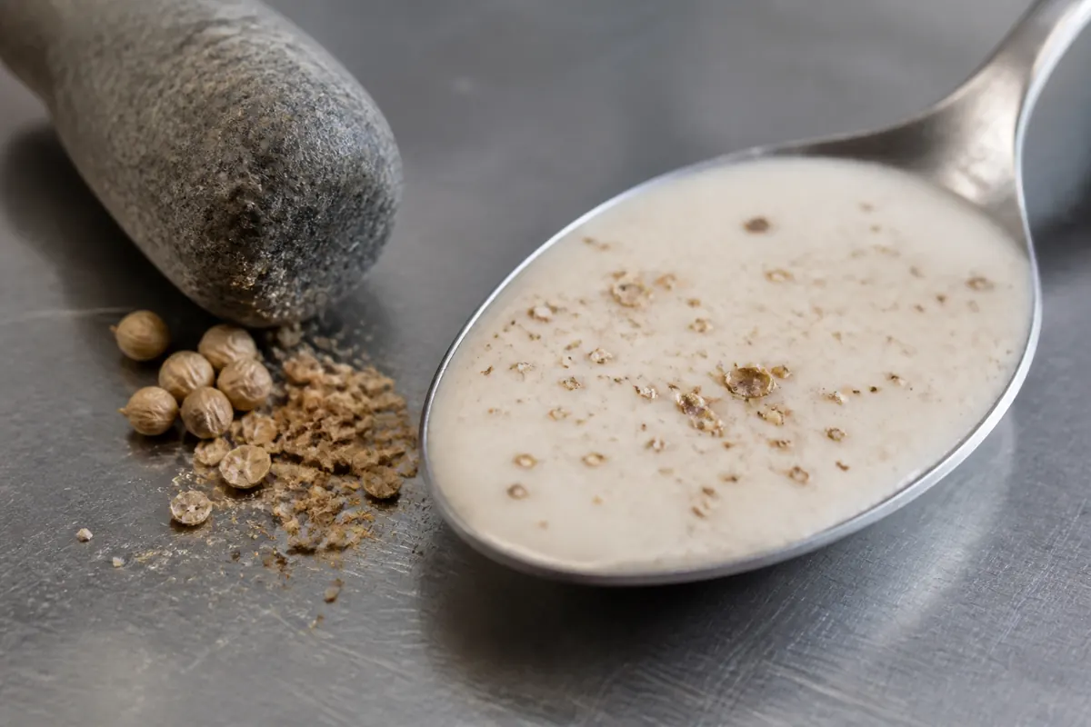 Cracked coriander seed dispersed through pale fish cream sauce - pink peppercorn substitutes | KnowTheSpices