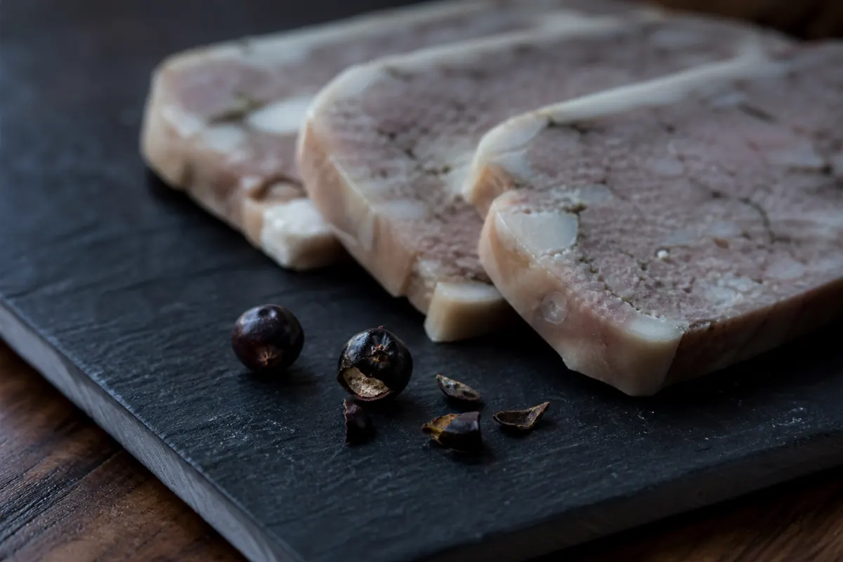 Measured crushed juniper berries beside sliced duck terrine - pink peppercorn substitutes | KnowTheSpices