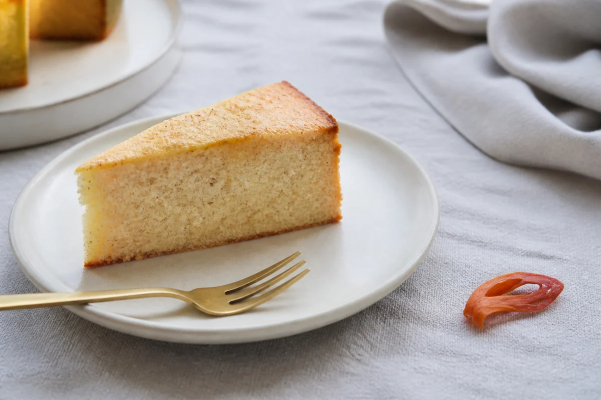 Pale butter cake with a restrained mace-specked crumb beside one orange mace blade - pumpkin pie spice substitutes | KnowTheSpices