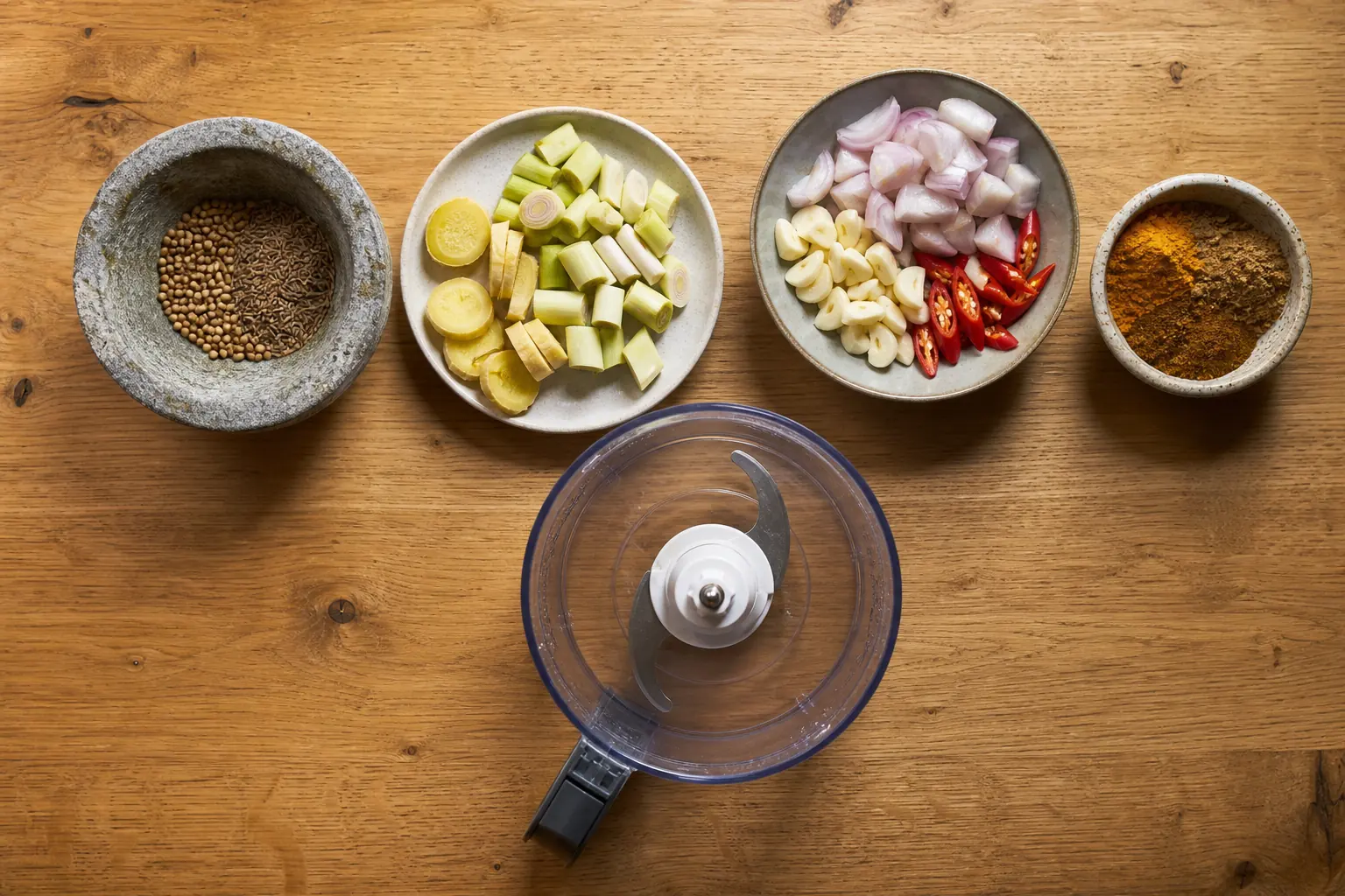 Spice paste ingredients arranged in grinding order with seeds, sliced roots, aromatics, and powder - making spice pastes | KnowTheSpices