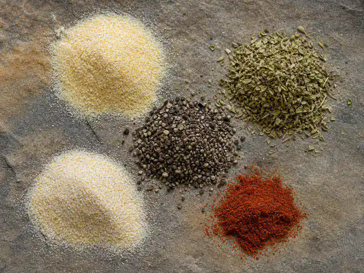 Garlic oregano black pepper and paprika arranged for a dry adobo blend